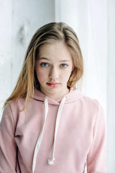 Teenage child in casual pink hoodie looking at camera — Stock Photo