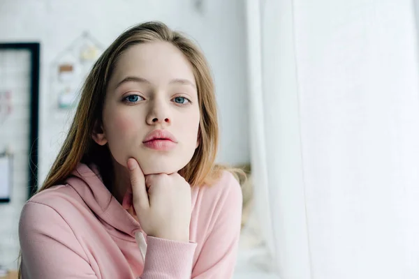 Teenage child in casual pink hoodie looking at camera — Stock Photo