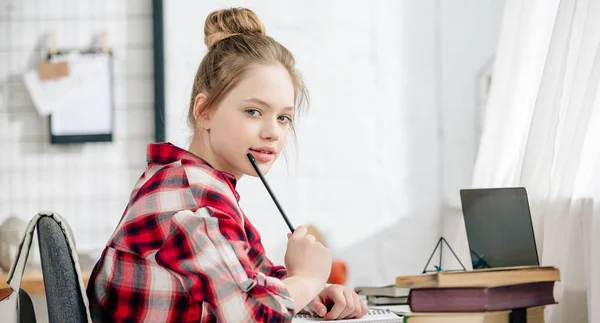 Panoramic shot of teenager in red checkered shirt doing homework — Stock Photo