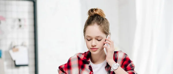 Plan panoramique d'une adolescente en chemise à carreaux parlant sur smartphone — Photo de stock