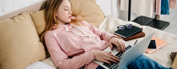 Panoramic shot of sleeping teenager lying on bed with laptop — Stock Photo