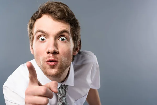 Aggressive businessman with funny face expression pointing with finger at camera — Stock Photo