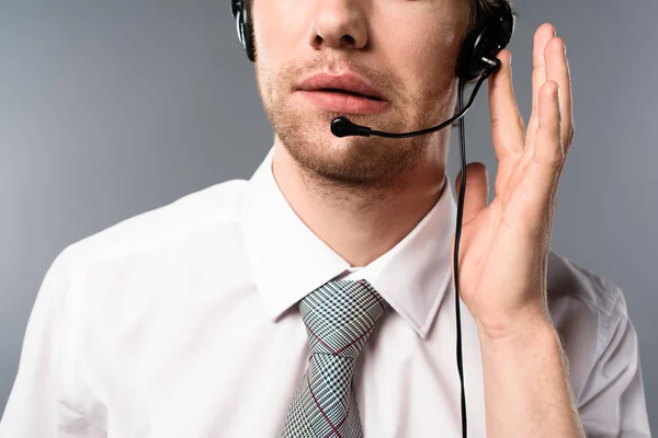 Vista recortada del operador del centro de llamadas serio tocando los auriculares - foto de stock