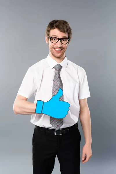 Hombre de negocios sonriente en gafas con el pulgar cortado en papel sobre fondo gris - foto de stock