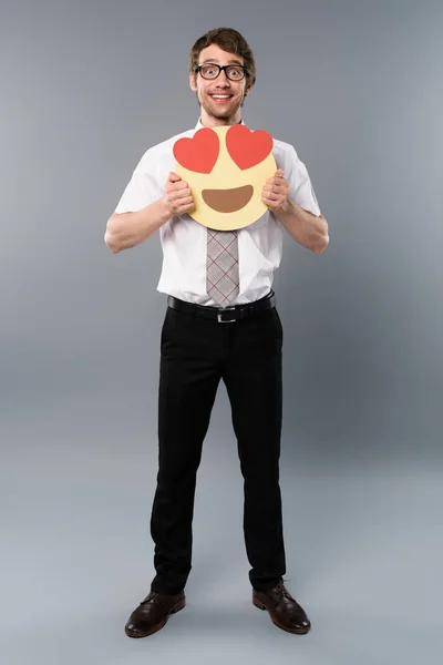 Hombre de negocios emocionado sosteniendo la cara sonriente con los ojos del corazón - foto de stock