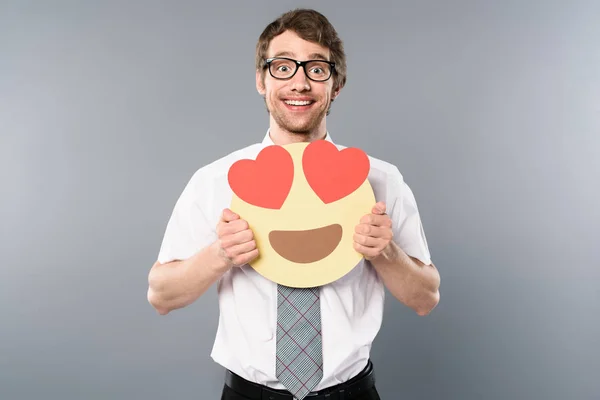 Hombre de negocios emocionado sosteniendo la cara sonriente con los ojos de corazón en las manos - foto de stock