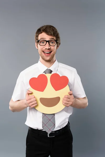 Счастливый бизнесмен с улыбающимся лицом с сердечными глазами в руках — стоковое фото