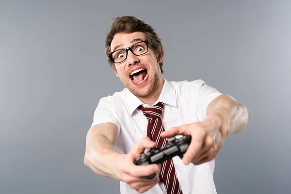 Aufgeregter Geschäftsmann spielt Videospiel mit Steuerknüppel auf grauem Hintergrund — Stockfoto
