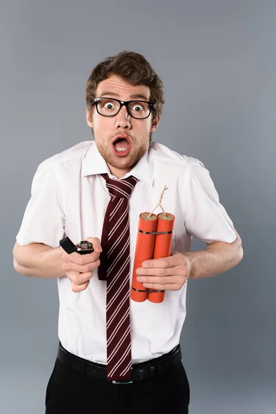 Empresário chocado em óculos segurando isqueiro e dinamite no fundo cinza — Fotografia de Stock
