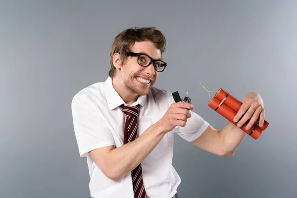 Cunning businessman holding lighter and dynamite on grey background — Stock Photo