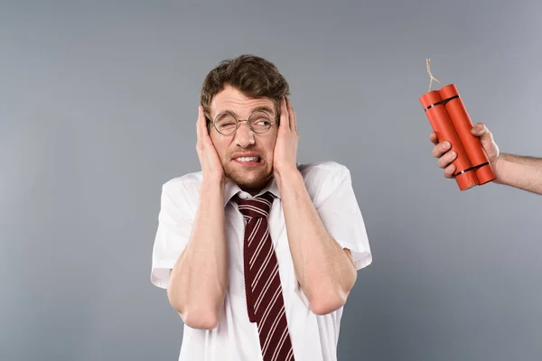 Uomo spaventato che si tiene per mano sulle orecchie mentre un altro che tiene dinamite — Foto stock