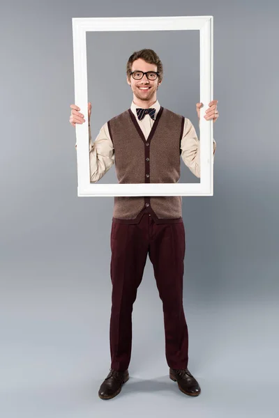 Glücklicher Mann mit weißem Rahmen auf grauem Hintergrund — Stockfoto