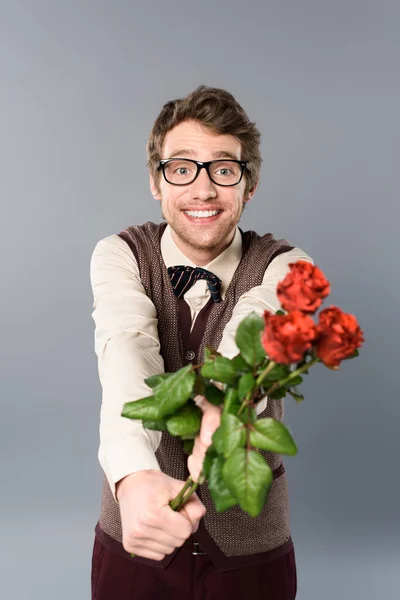 Uomo sorridente in bicchieri regalo bouquet di rose — Foto stock