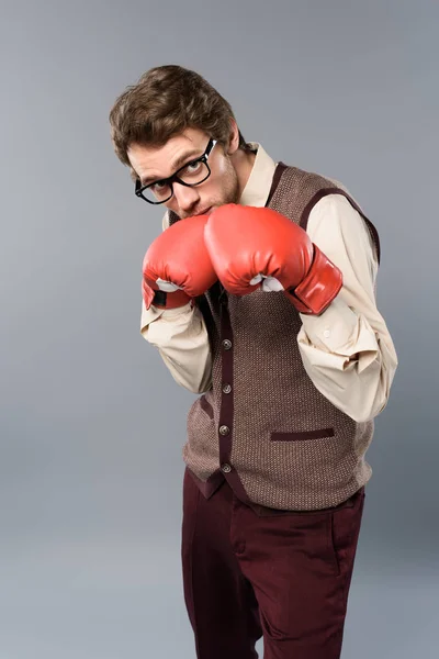 Ernster Mann mit Brille und Boxhandschuhen auf grauem Hintergrund — Stockfoto