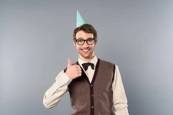 Smiling man in party cap and glasses showing thumb up — Stock Photo