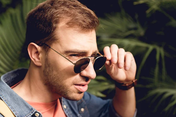 Schöner erwachsener Tourist mit Sonnenbrille im tropischen Wald — Stockfoto