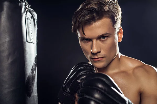 Boxer steht neben Boxsack und blickt in Kamera — Stockfoto