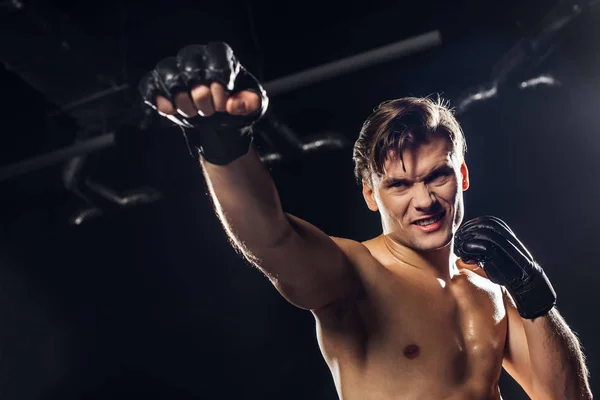 Low angle view of angry boxer in gloves looking away — Stock Photo