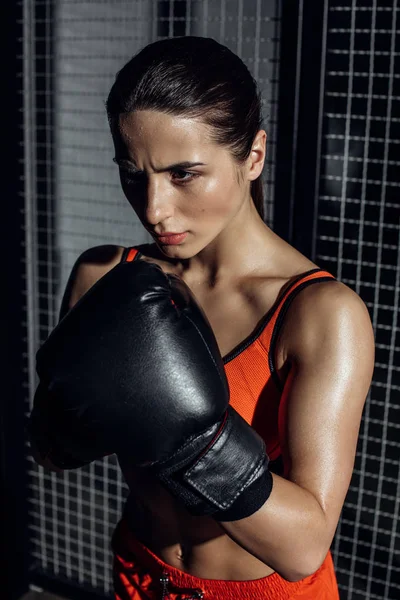 Concentrated pretty boxer in black boxing glove looking away — Stock Photo