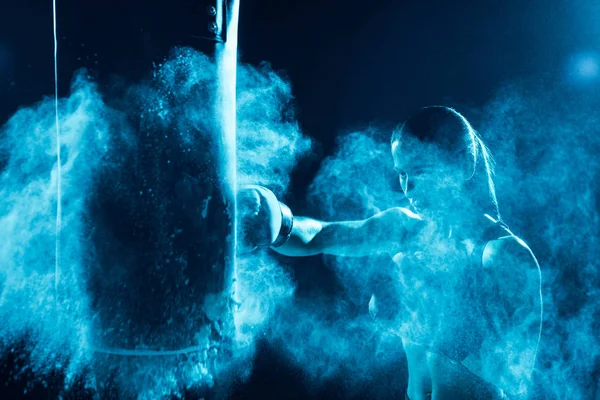 Boxer féminin dans l'entraînement des gants de boxe avec sac de boxe — Photo de stock