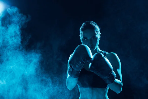 Frontansicht eines ernsthaften Boxers in Boxhandschuhen, der in die Kamera blickt — Stockfoto
