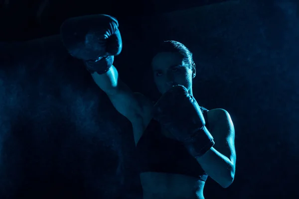 Boxer sérieux dans la formation des gants de boxe et détourner les yeux — Photo de stock