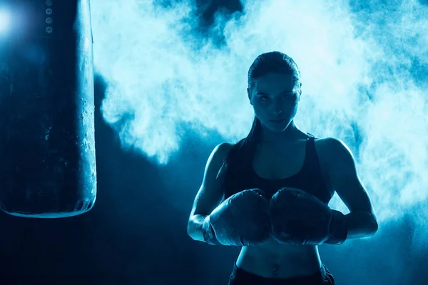 Frontansicht eines selbstbewussten Boxers in Boxhandschuhen, der in die Kamera blickt — Stockfoto