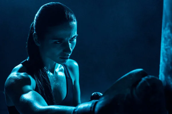 Strong female boxer in boxing glove looking away — Stock Photo