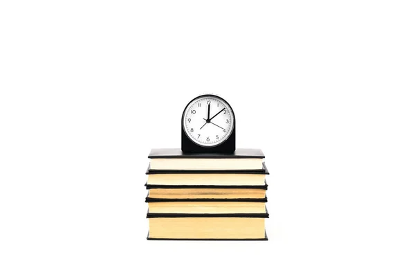 Orologio e pila di libri isolati su bianco — Foto stock