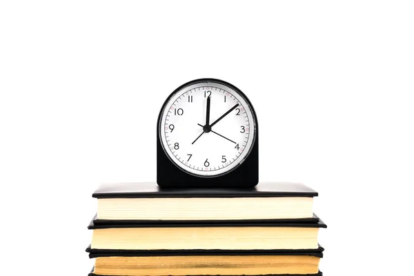 Relógio e pilha de livros isolados em branco — Fotografia de Stock