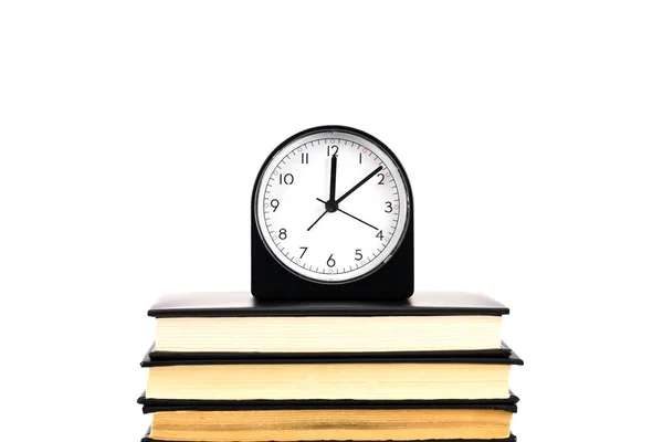 Orologio e pila di libri isolati su bianco — Foto stock