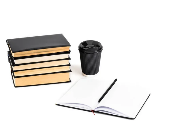 Stack of books, paper cup, notebook and pencil on white — Stock Photo