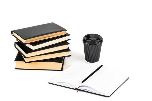 Stack of books, paper cup, notebook and pencil on white — Stock Photo