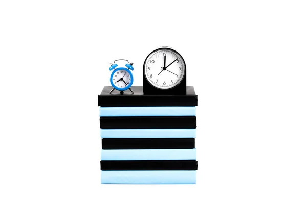 Часы и стопка книг изолированы на белом — стоковое фото