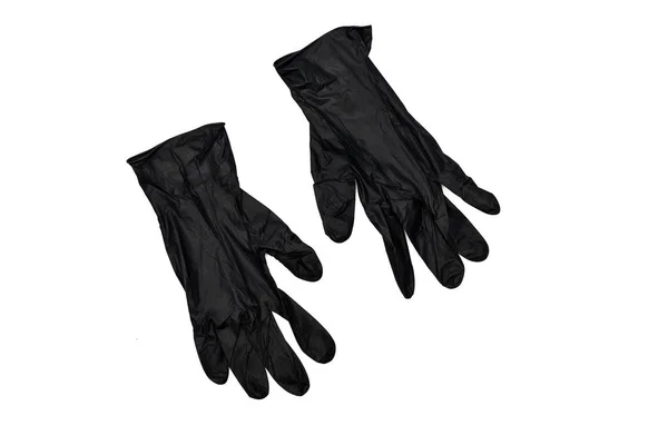 Dos guantes de goma negros aislados en la superficie blanca - foto de stock