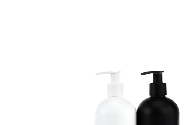 Frascos cosméticos blancos y negros aislados en blanco - foto de stock