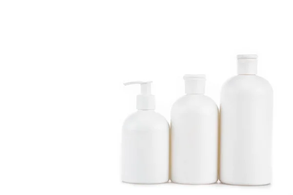 Tre bottiglie cosmetiche bianche di plastica isolate su bianco — Foto stock