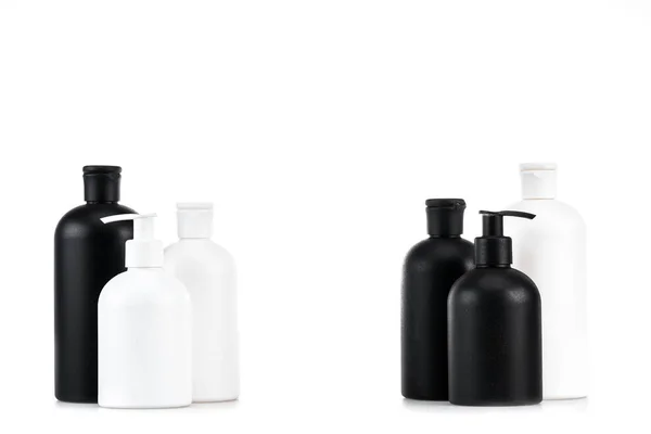 Frascos cosméticos blancos y negros aislados en blanco - foto de stock
