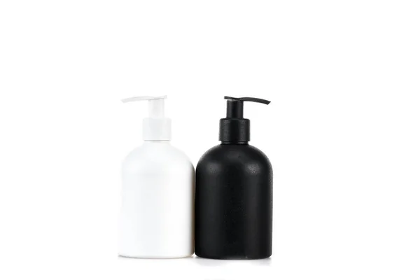Bottiglie cosmetiche bianche e nere isolate su bianco — Foto stock