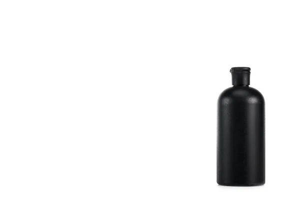Botella cosmética negra con tapa aislada en blanco - foto de stock