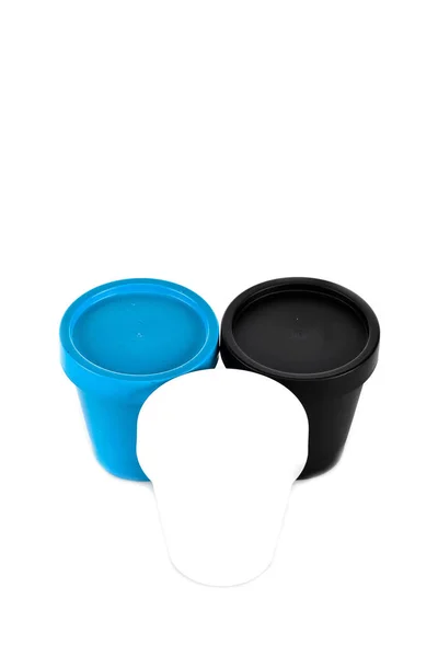 Tazas de plástico blanco, negro y azul aisladas en blanco - foto de stock