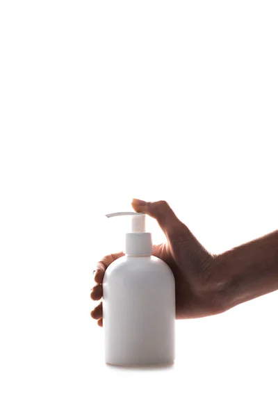 Vista recortada de la mujer utilizando botella de spray cosmético aislado en blanco - foto de stock