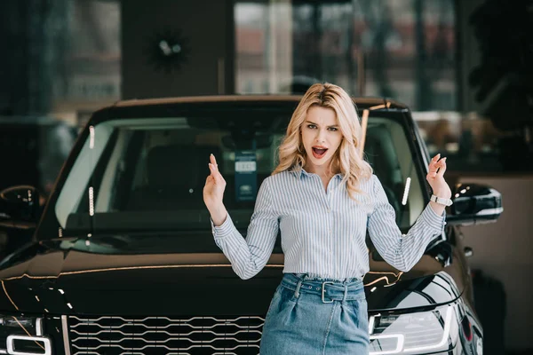 Attrayant blonde fille crier et gesticuler près de voiture noire — Photo de stock