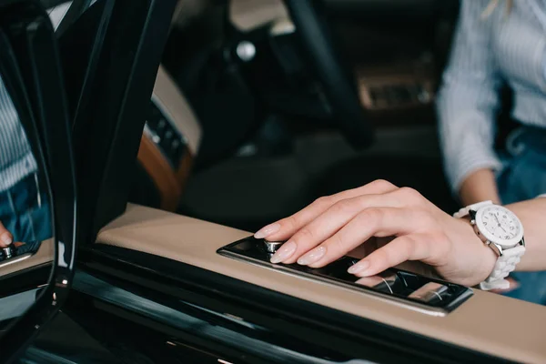 Vue recadrée de la jeune femme appuyant sur le bouton sur la porte de la voiture — Photo de stock