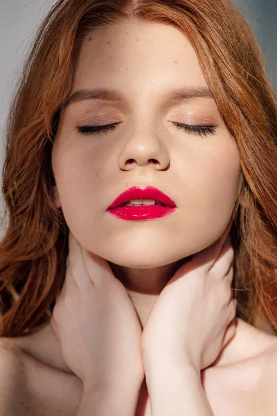 Beautiful young seductive redhead woman with red lips posing with eyes closed — Stock Photo