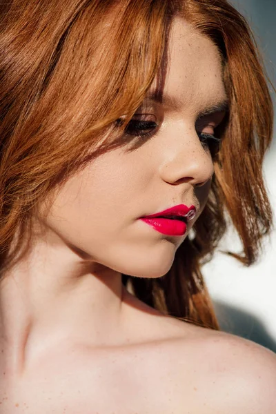 Hermosa joven pelirroja con labios rojos mirando hacia otro lado - foto de stock