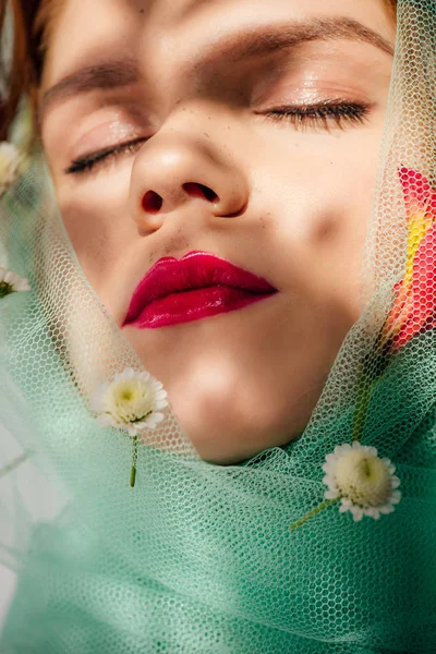 Belle jeune femme aux yeux fermés et aux lèvres rouges recouvertes de voile de fleurs — Photo de stock