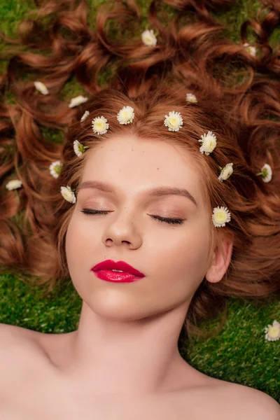 Beautiful young redhead woman with red lips and chrysanthemum flowers in hair — Stock Photo