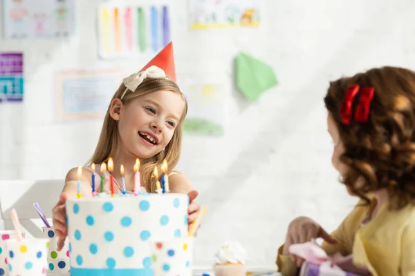 Bambini carini seduti al tavolo della festa con torta durante la celebrazione del compleanno — Foto stock