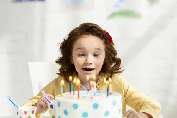 Selective focus of adorable preteen sitting at table with birthday cake at home — Stock Photo